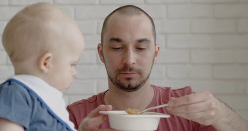 A Parent Feeding a Baby 