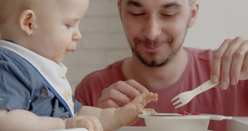 Adult Man Feeding a Toddler