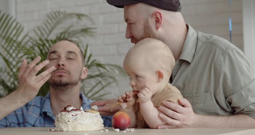 A Couple and Their Baby Eating Cake