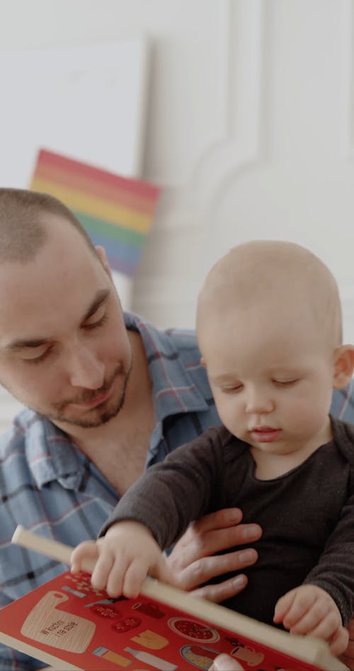 A Couple Reading a Book to a Baby