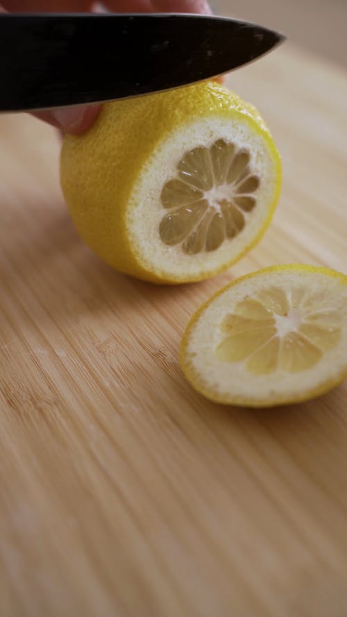 Person Slicing the Lemon