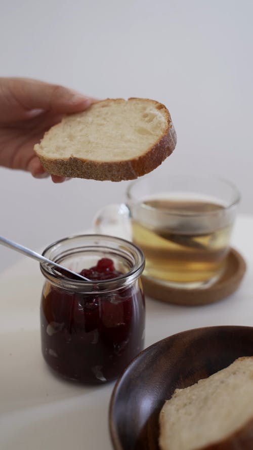 Person Putting Jam on the Bread