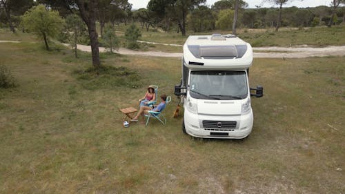 A Couple Resting Outside their Campervan