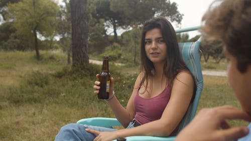 Couple Drinking Beer Next to Parked Trailer