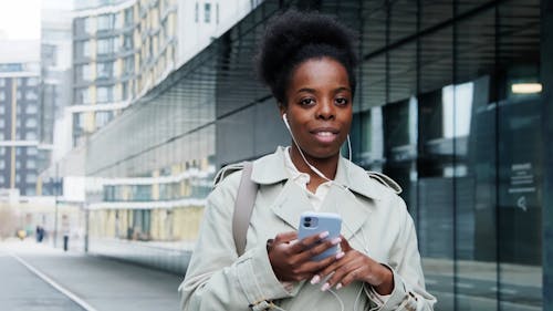 A Woman Holding her Cellphone in an Urban Area