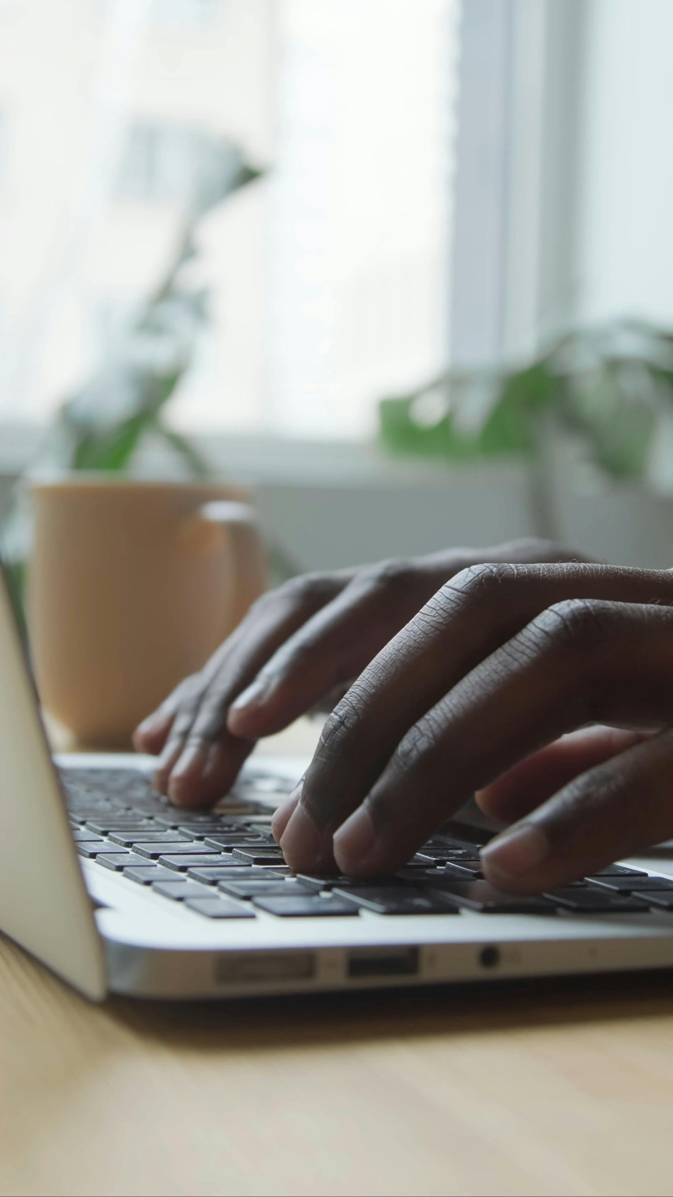 black person typing fingers laptop