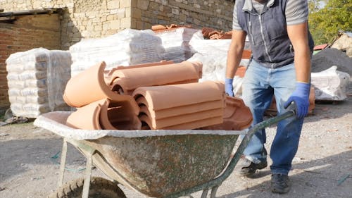 A Person Transporting Bricks using a Wheelbarrow