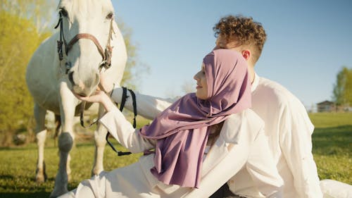 A Couple Feeding a Horse