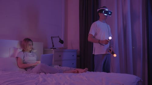 A Man Playing a Video Game Using a VR Headset and Controllers