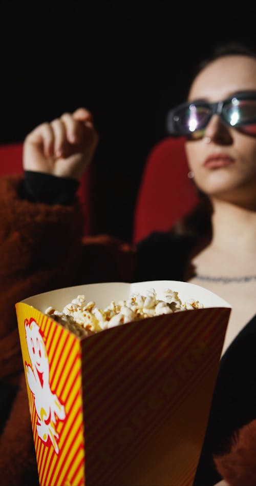 Woman Eating Popcorn while Watching a Movie
