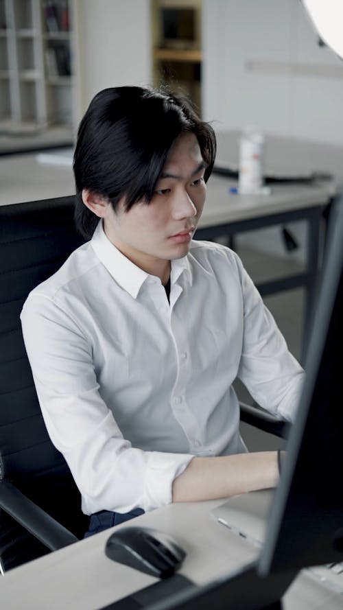 A Man Using a Laptop at an Office