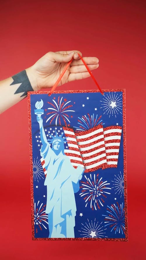 A Hand Holding a Patriotic Gift Bag 