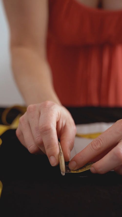 A Woman Using a Tailors Chalk on Fabric