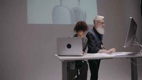 A Man and a Woman using a Computer and a Laptop
