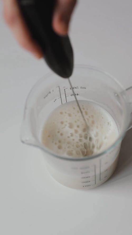 A Person Using a Milk Frother