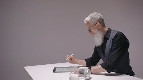 An Elderly Man Drawing on a Tablet