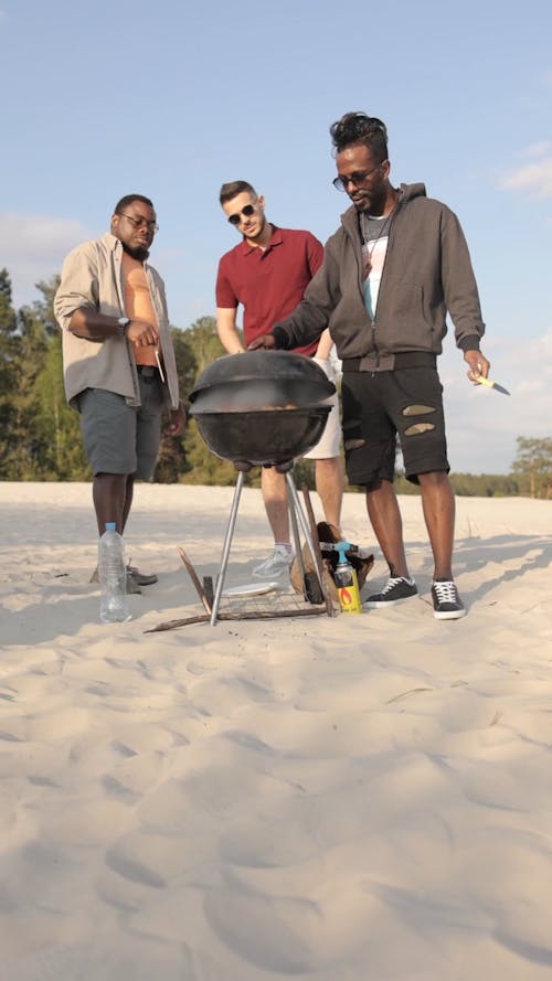 Men Grilling Meat in the Beach