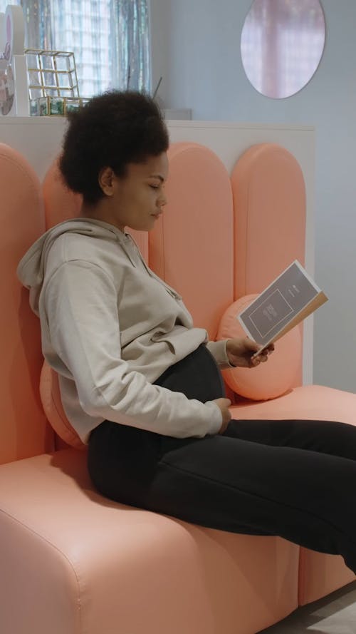 Pregnant Woman Reading Brochure while on the Beauty Salon