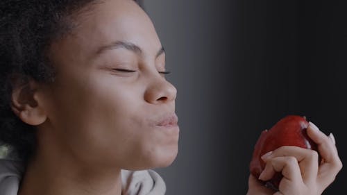 A Woman Eating An Applesmiles