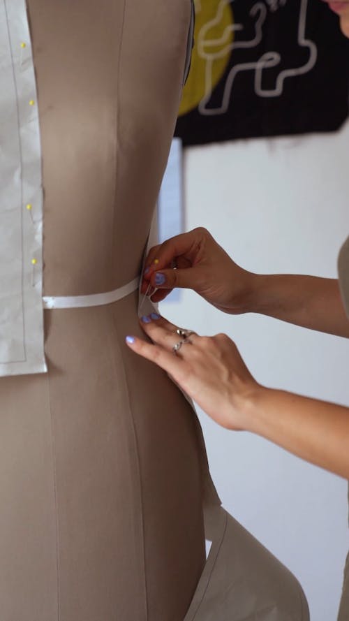 A Fashion Designer Fitting the Dress on the Mannequin