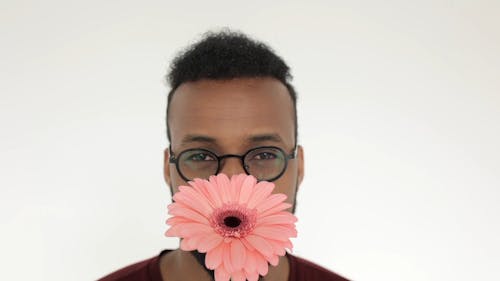 A Man Smelling A Flower