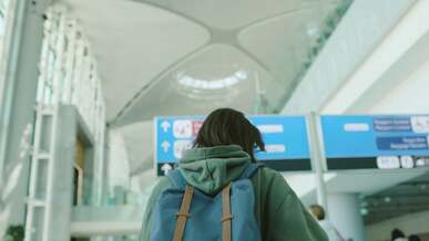 woman with backpack walking in the airport terminal