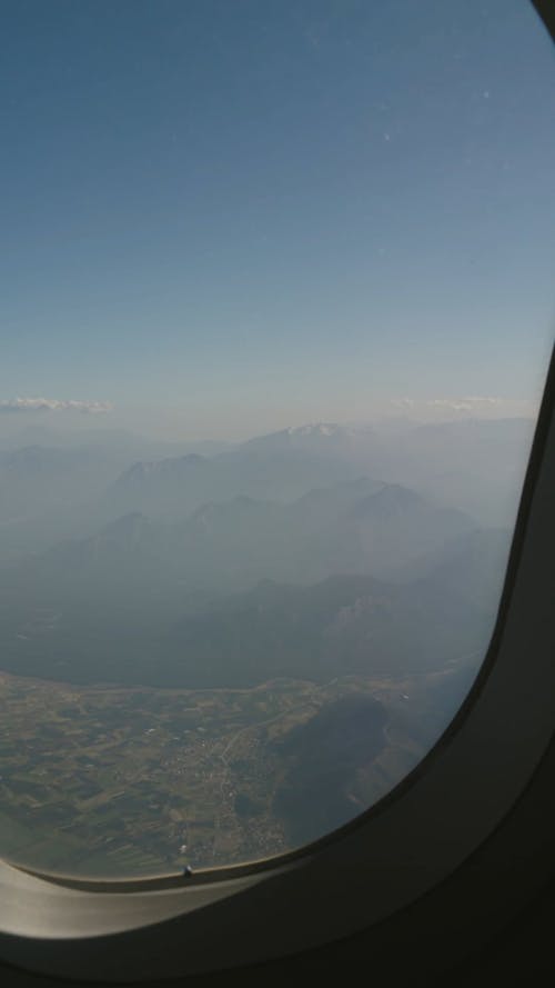 View Of Foggy Mountains From An Airplane Window