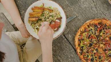 woman eating pizza and salad