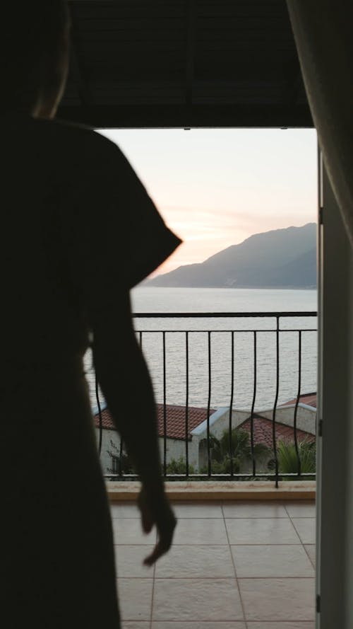 Woman Looking At The View Of The Sea From Balcony