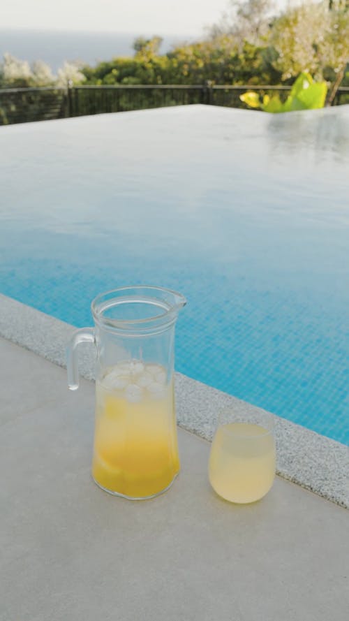 A Pitcher And Glass Of Juice On Poolside