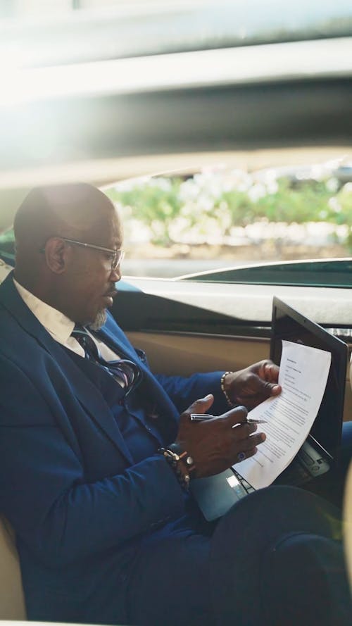 Businessman Reading Document Inside A Car