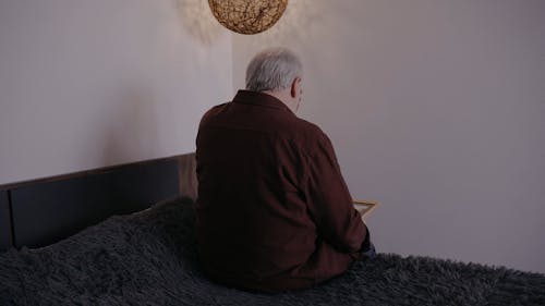 Elderly Man Grieving while Looking at the Photo