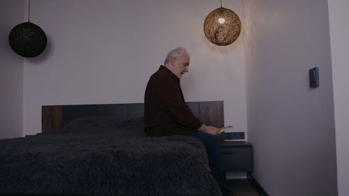 A Sad Elderly Man Looking at a Picture Frame