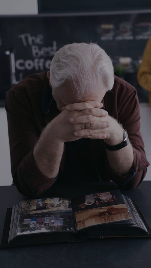 An Elderly Man Looking at a Photo Album