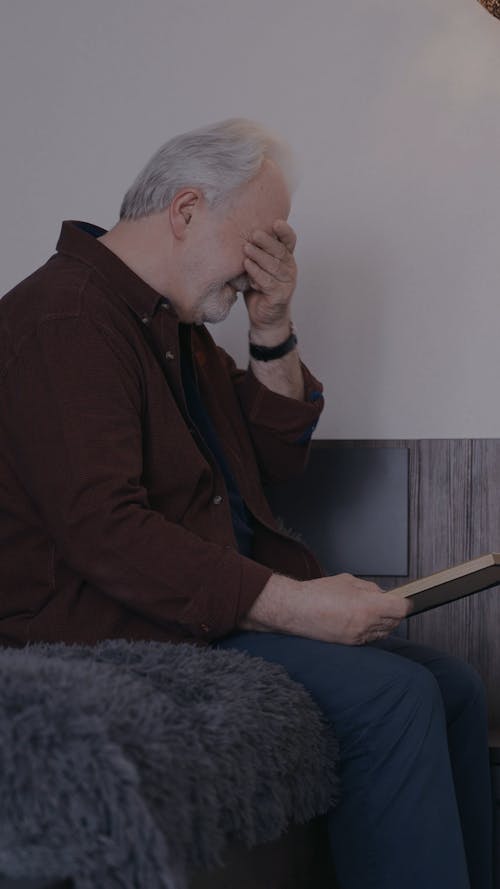 Elderly Man Looking at a Picture Frame