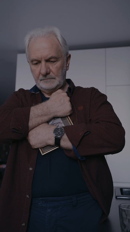 An Elderly Man Hugging a Picture Frame