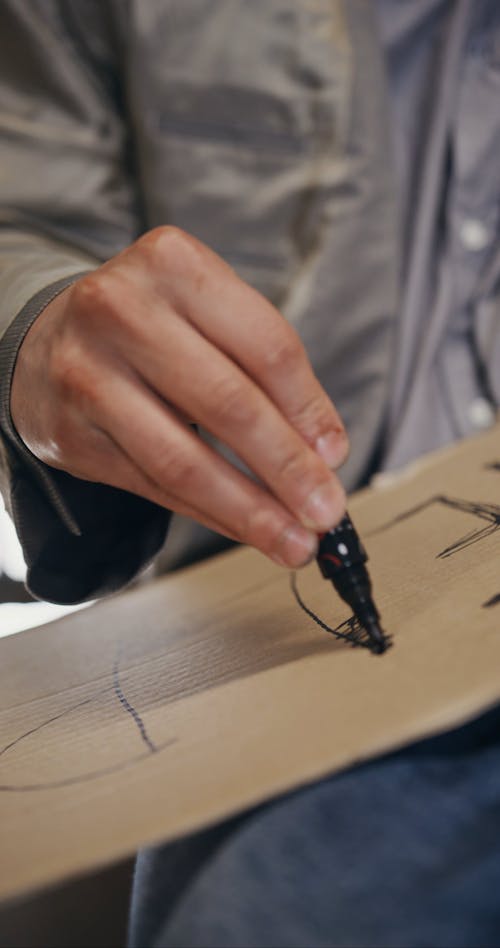A Homeless Man Writing Help on a Cardboard