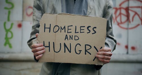 A Homeless Person Holding a Sign