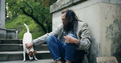 A Homeless Man Hugging a Dog