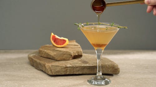 A Person Adding Syrup in a Cocktail Drink