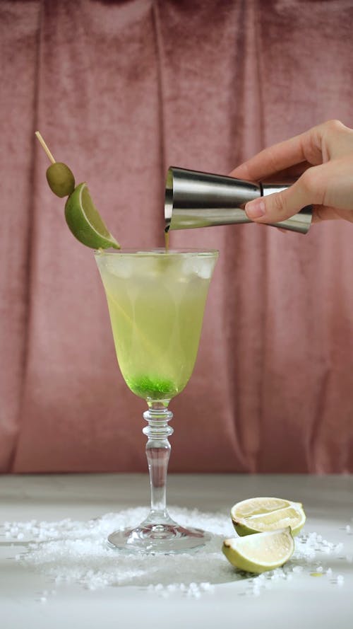 Person Pouring Liquid into a Drinking Glass