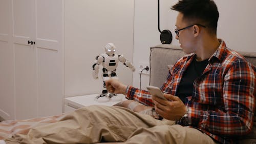 A Man Playing with a Toy Robot