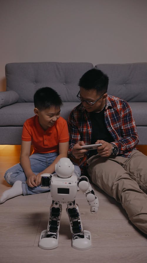 Father and Son Playing with a Robot