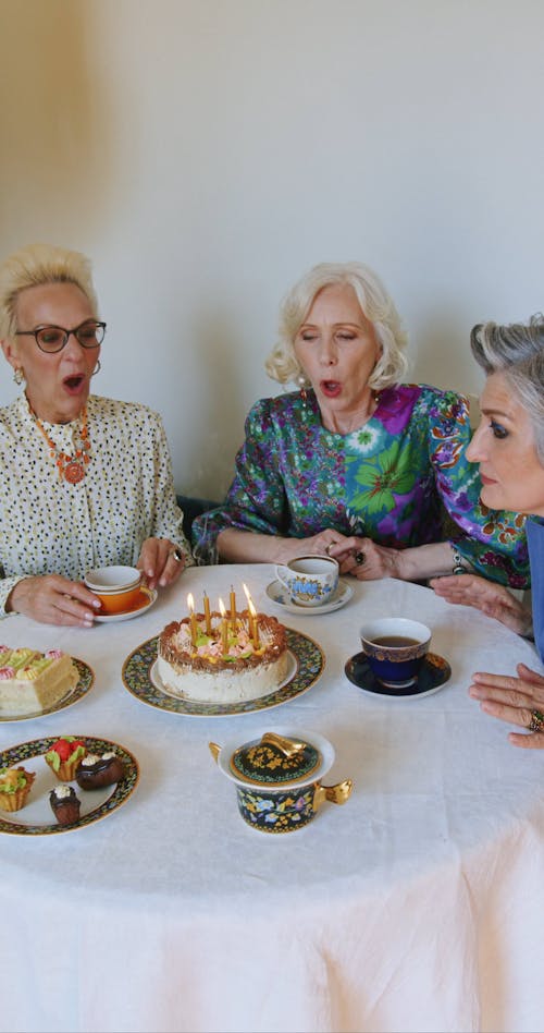 Three Elderly Women Blowing Out a Candles