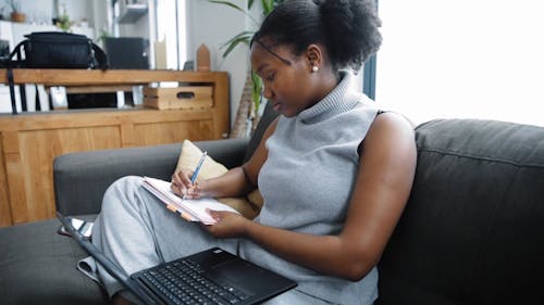 A Woman Taking Notes on a Couch