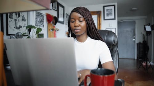 A Woman Typing on Her Laptop