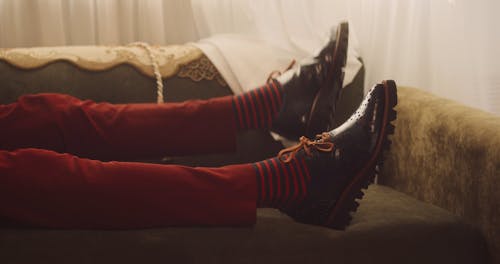 A Person Wearing Leather Shoes While Resting on a Couch