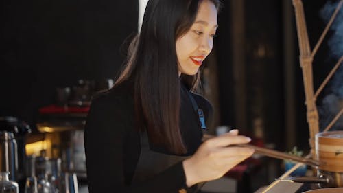 Woman Placing Dumplings on a Bamboo Plate