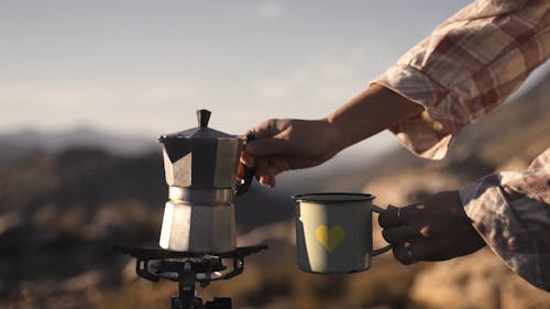 A Person Pouring Coffee to a Mug