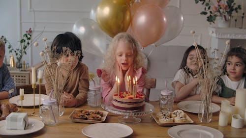 Girl Blowing the Candles on the Birthday Cake